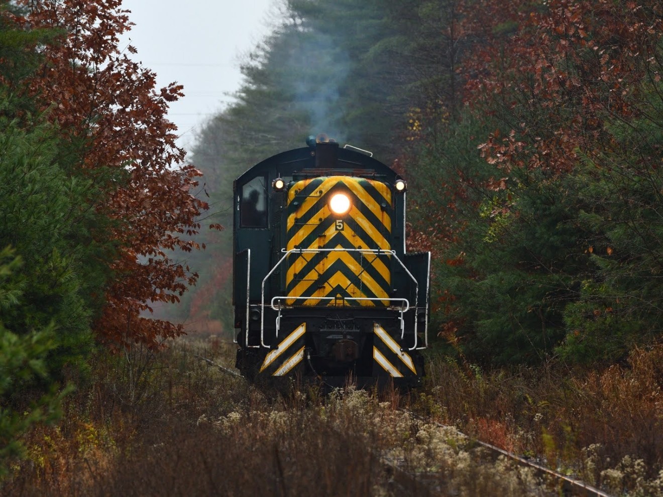 a train on a track with smoke coming out of it