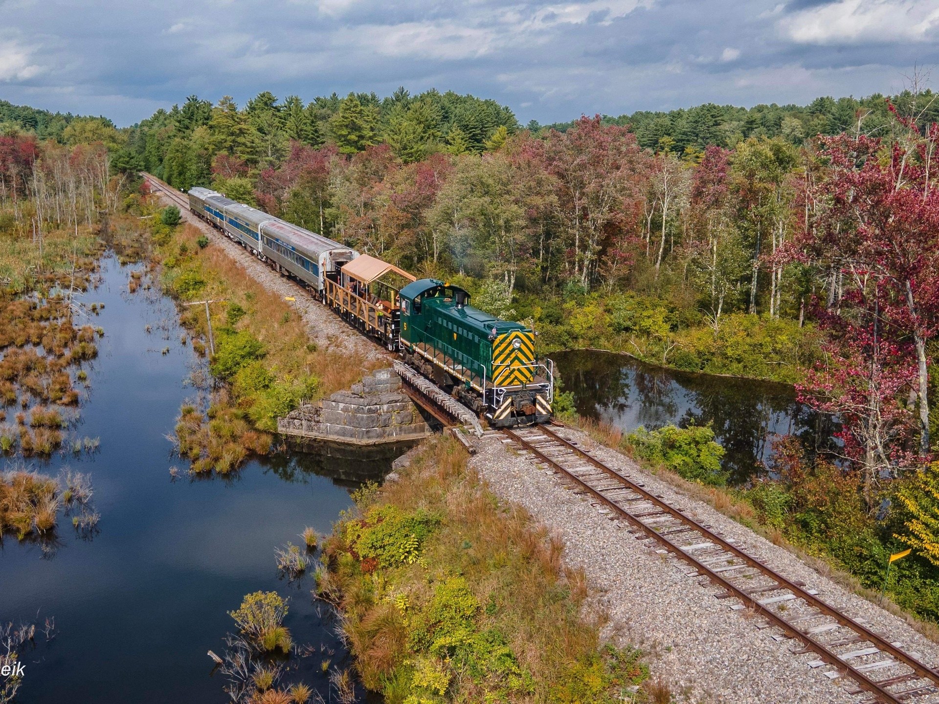 a train traveling down train tracks next to a river