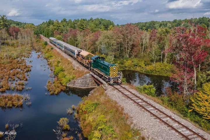 a train traveling down train tracks next to a river