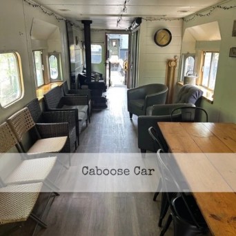 Interior of a converted train car with seating and tables.