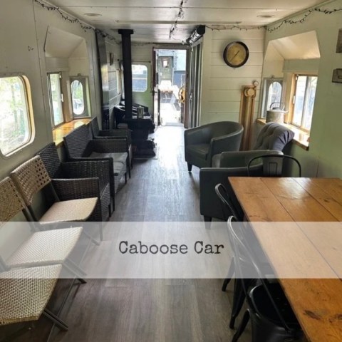 Interior of a converted train car with seating and tables.