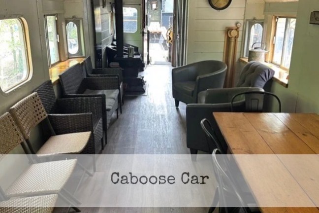Interior of a converted train car with seating and tables.