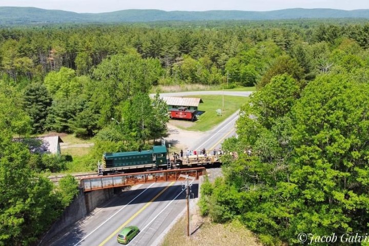 a train traveling down train tracks near a forest