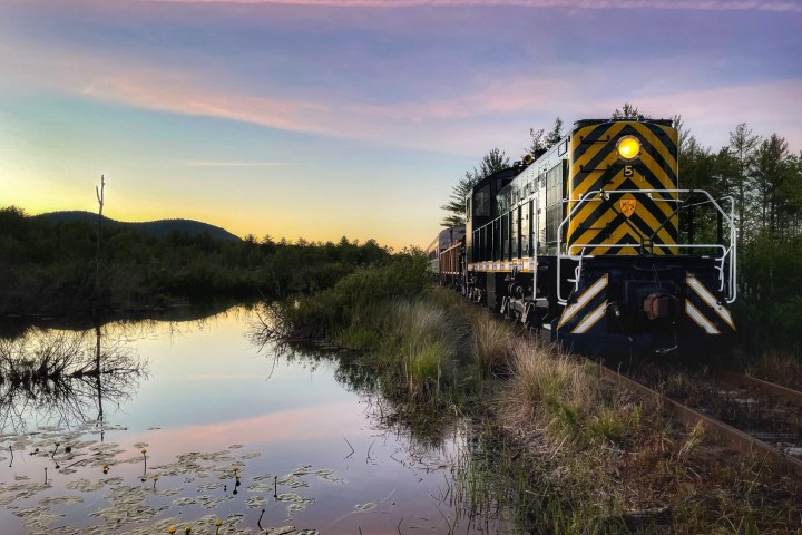 a train traveling down tracks next to a body of water