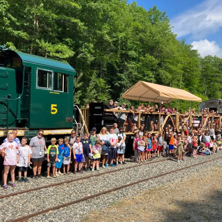 a group of people standing next to a train