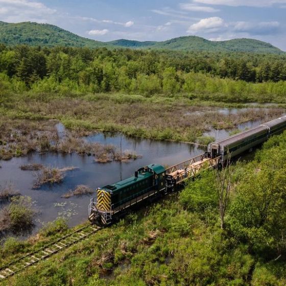 a train traveling down train tracks next to a body of water