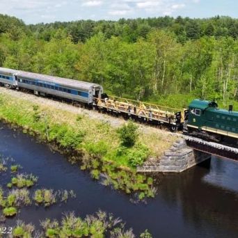 a train traveling down train tracks near a river