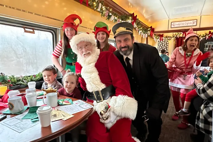 a group of people sitting at a table with a cake
