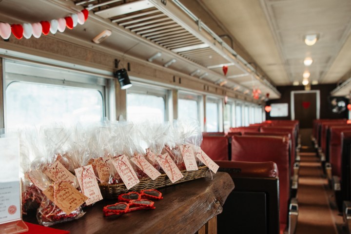 Train car with red seats, Valentine decorations, and gift bags arranged on a wooden counter.