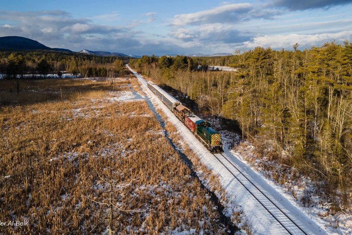 a train is on the side of a snow covered field